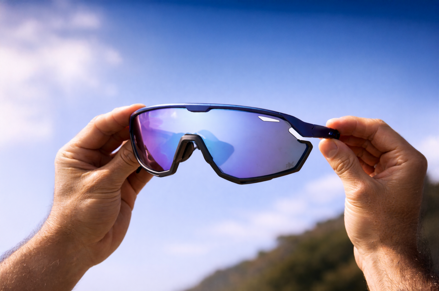 Blauwe sport zonnebril met gespiegelde glazen, een voorbeeld van duurzame TR90 brillen tegen een heldere lucht.