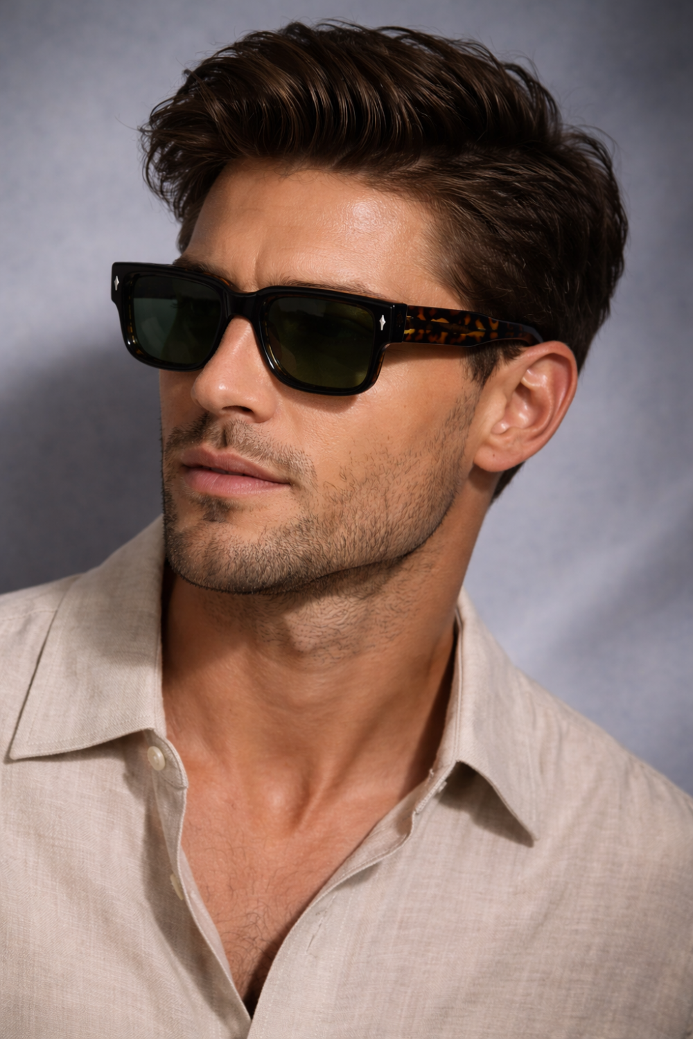 Man met bruin haar draagt cellulose propionaat bril met schildpadpatroon en een beige linnen overhemd.