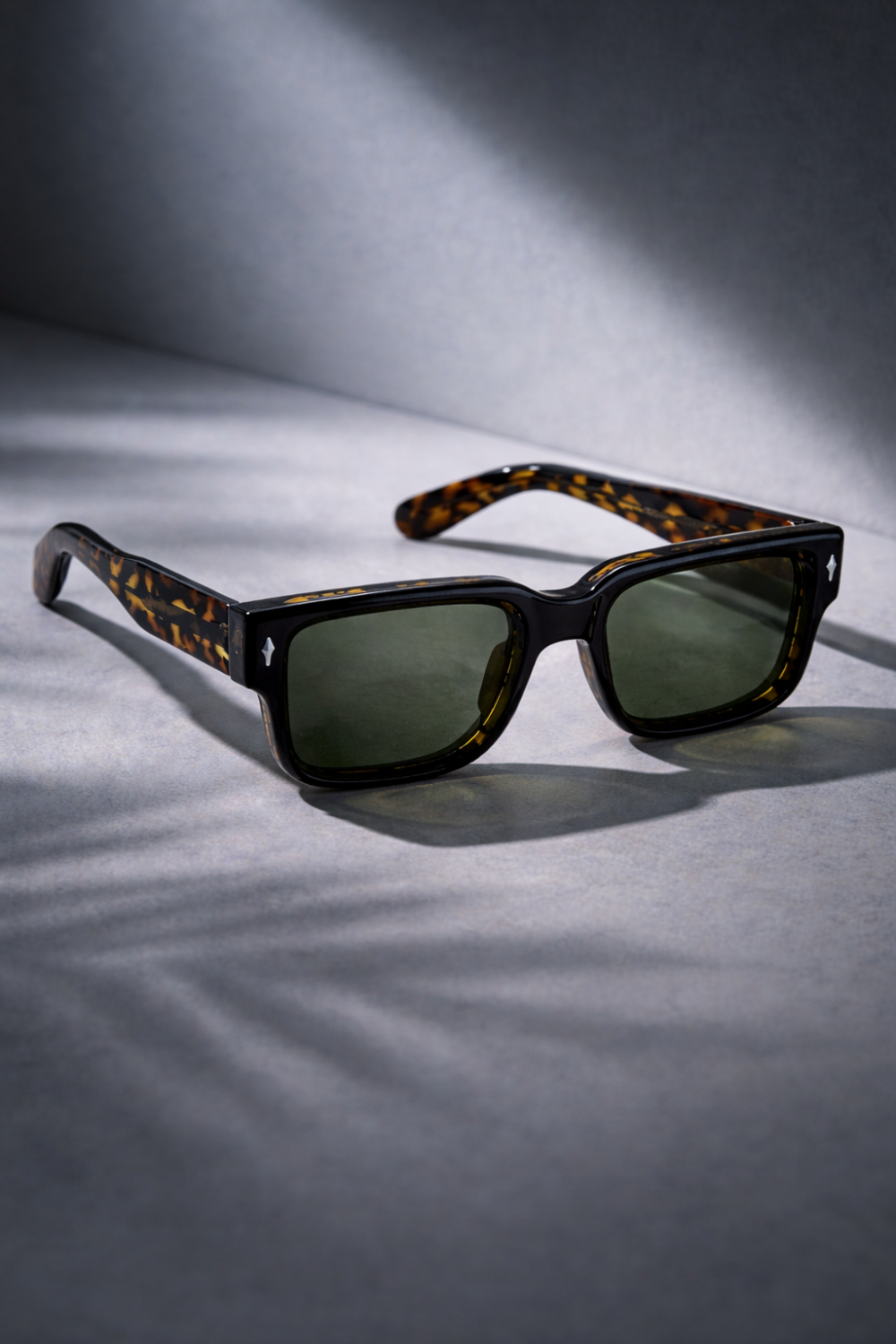 Elegantes gafas de sol de concha de tortuga de propionato de celulosa con cristales oscuros y monturas rectangulares clásicas.