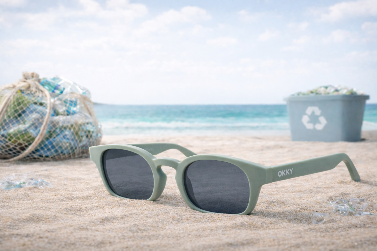 Green sustainable glasses by OKKY on the beach with plastic waste and a recycling bin in the background.